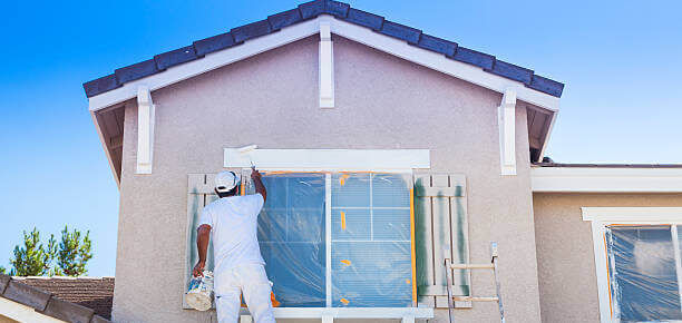 Busy House Painter Painting The Trim And Shutters Of A Home.
